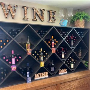 Wine display inside WAM Wine Bar in Cole Camp, featuring bottles, rustic decor, and a welcoming atmosphere.