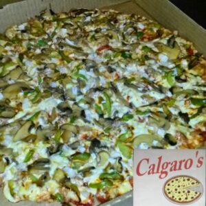 Close-up of a fully loaded pizza from Calgaro’s in Cole Camp, Missouri, known for award-winning flavor.