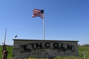 City of Lincoln, Missouri welcome sign with American flag on a clear day