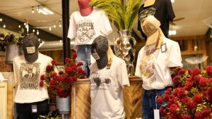 Boutique display of vintage graphic tees, hats, and floral décor in Benton County, Missouri.