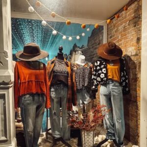Fall clothing display with cozy sweaters, hats, and jeans inside a Benton County boutique participating in the annual Boutique Crawl.