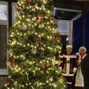 Santa and Mrs. Claus beside a beautifully lit Christmas tree during Cole Camp’s Christkindlmarket, part of the town’s German holiday events.