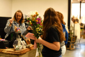 Shopper holding fresh flowers at a local boutique checkout in Benton County, Missouri