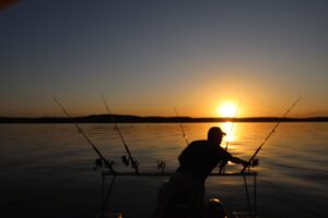 Spring crappie fishing at sunset on Truman Lake in Missouri with multiple fishing rods set up on a boat