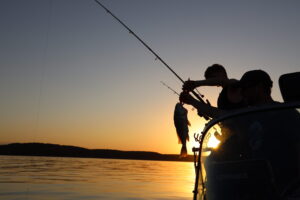 Visitors fishing from a boat at sunset on Truman Lake near Warsaw