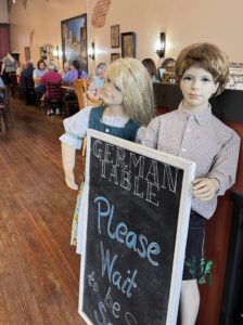A German Table sign welcomes guests inside a restaurant in Cole Camp, Missouri, celebrating the town's German heritage.